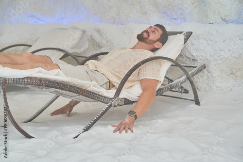 Man lying on a chair in a salt cave, smiling and relaxed photo