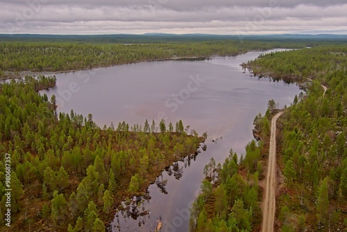 Aerial view of lake Båtvatnet shore and gravel road at Ovre Pasvik National Park on a cloudy spring day, Norway. photo