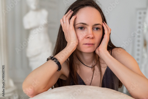 Woman suffering from headache or stress holding her hands to her hands