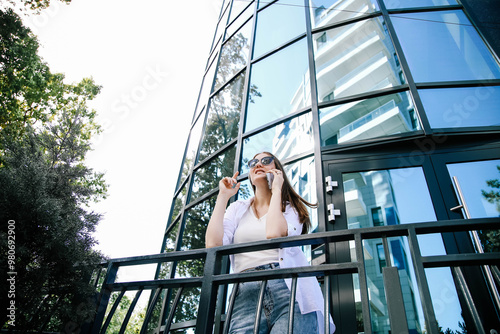 Attractive business woman talking on the phone near a business center.