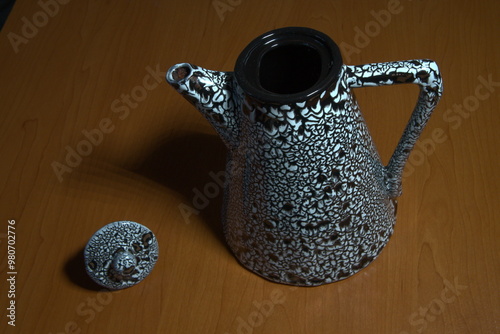 ceramic coffee pot with patterns on the table surface. isolated