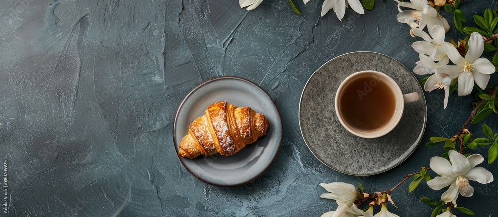 A high angle view of a croissant served with coffee and flowers with ample copy space image available A high angle view of a croissant served with coffee and flowers with ample copy space image available