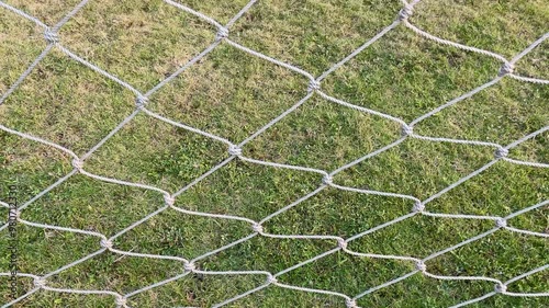 Football goal net with green grass background
