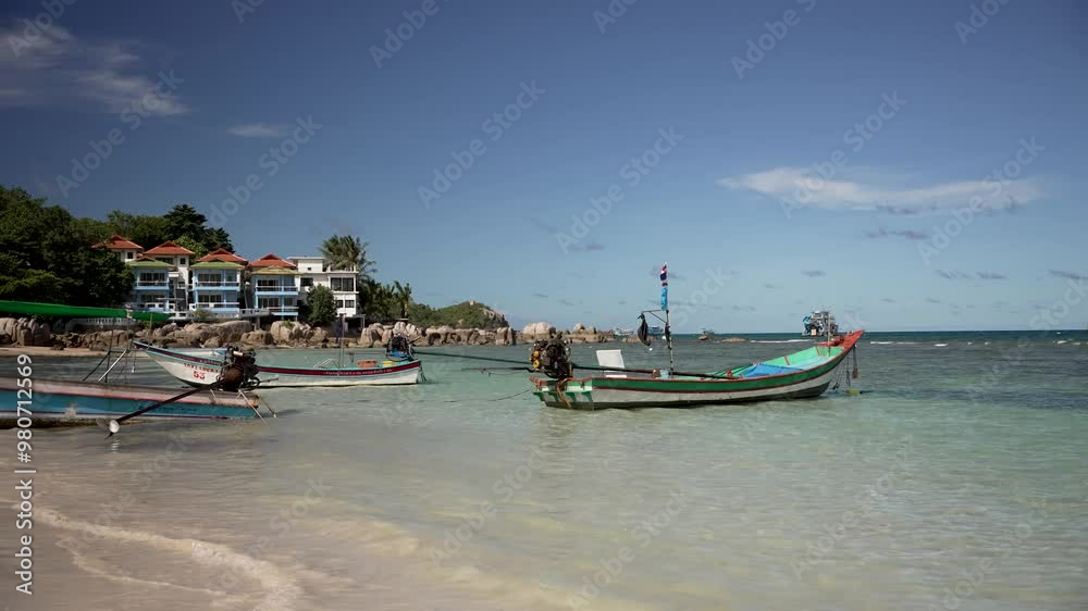 Empty longtail boats quietly moored in the shallow waters of Sairee Beach on Koh Tao, Thailand. Locked Off Shot Empty longtail boats quietly moored in the shallow waters of Sairee Beach on Koh Tao, Thailand. Locked Off Shot