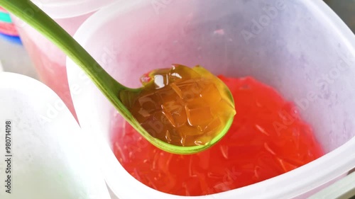 A person holds a spoon with the traditional Indonesian snack 