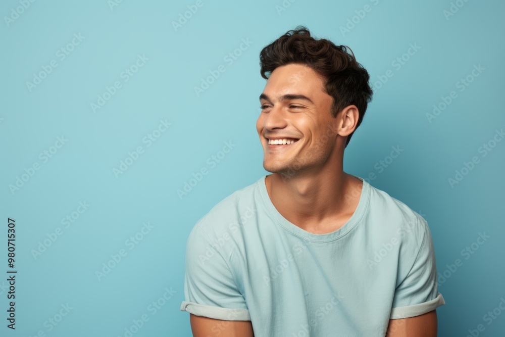 Portrait of a satisfied man in his 20s donning a trendy cropped top in soft blue background Portrait of a satisfied man in his 20s donning a trendy cropped top in soft blue background