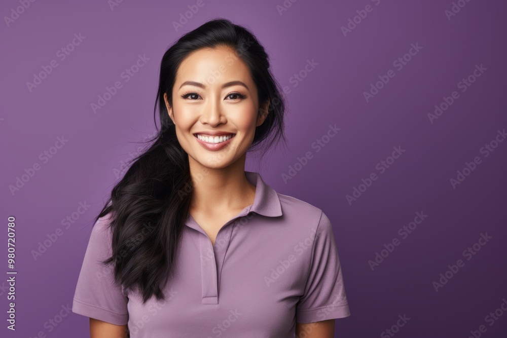Portrait of a smiling asian woman in her 30s wearing a sporty polo shirt on soft purple background Portrait of a smiling asian woman in her 30s wearing a sporty polo shirt on soft purple background