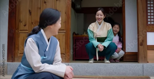 A middle-aged Korean woman visits her neighbor’s house, greeted with a warm smile. Their friendly interaction highlights the importance of good neighborly relations and social connections
