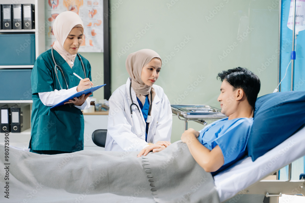 Obraz premium Doctors and nurses in hijabs offering care to a patient in a hospital ward, showcasing teamwork, professionalism