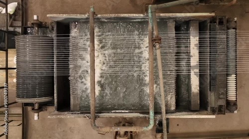 steel wire making process in factory.industrial grade heavy duty metal rope manufacturing plant. wires are going through water flow. old machinery working.