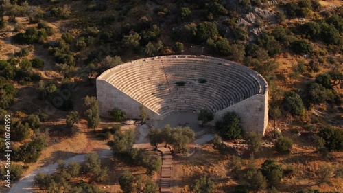 Antiphellos Ancient City - Aerial telephoto orbit around open air stadium seating under golden hour light along Kas coastline in Antalya, Turkey. photo