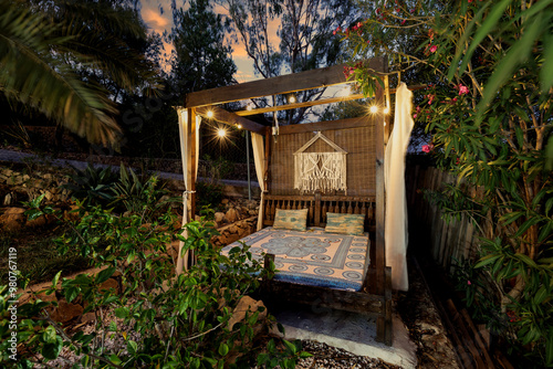 Garden with wooden gazebo in the evening. The sky at sunset, a place of privacy and relaxation.