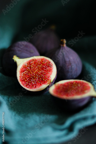 Close up of fresh ripe fig fruits in green fabric with dark shadows photo