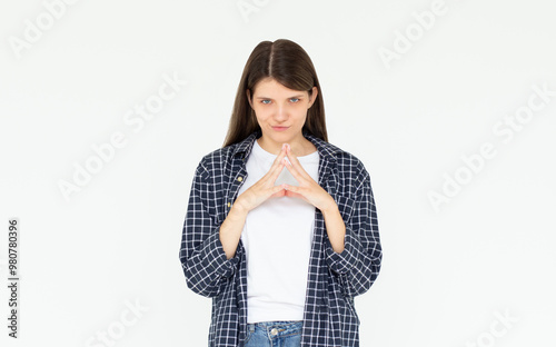 I have great evil plan. Confident and tricky woman in blue shirt, holding fingers together and smirking at camera, having some bad intention in mind, planning to commit crime