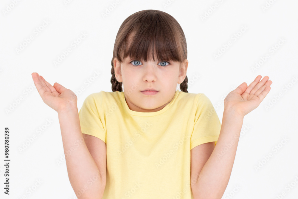 Teenager girl with yellow t-shirt having doubts while raising hands and shoulders on white background Teenager girl with yellow t-shirt having doubts while raising hands and shoulders on white background