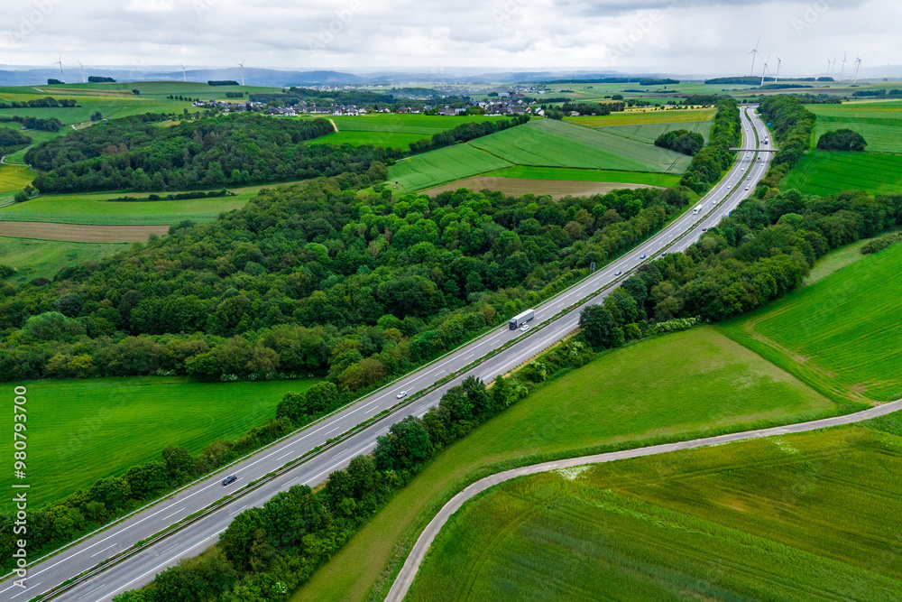 cargo truck and cars on the highway. asphalt road among green forest and beautiful rain clouds. cargo delivery and transportation concept cargo truck and cars on the highway. asphalt road among green forest and beautiful rain clouds. cargo delivery and transportation concept