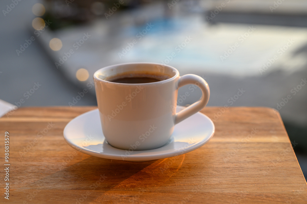 a cup of black Turkish coffee on the balcony with a swimming pool in the background a cup of black Turkish coffee on the balcony with a swimming pool in the background