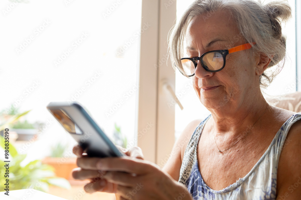 Senior woman using smartphone while wearing glasses Senior woman using smartphone while wearing glasses