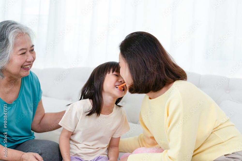 Asian mother and daughter enjoying in living room, Grandparents enjoying with grandchild in living room at home Asian mother and daughter enjoying in living room, Grandparents enjoying with grandchild in living room at home