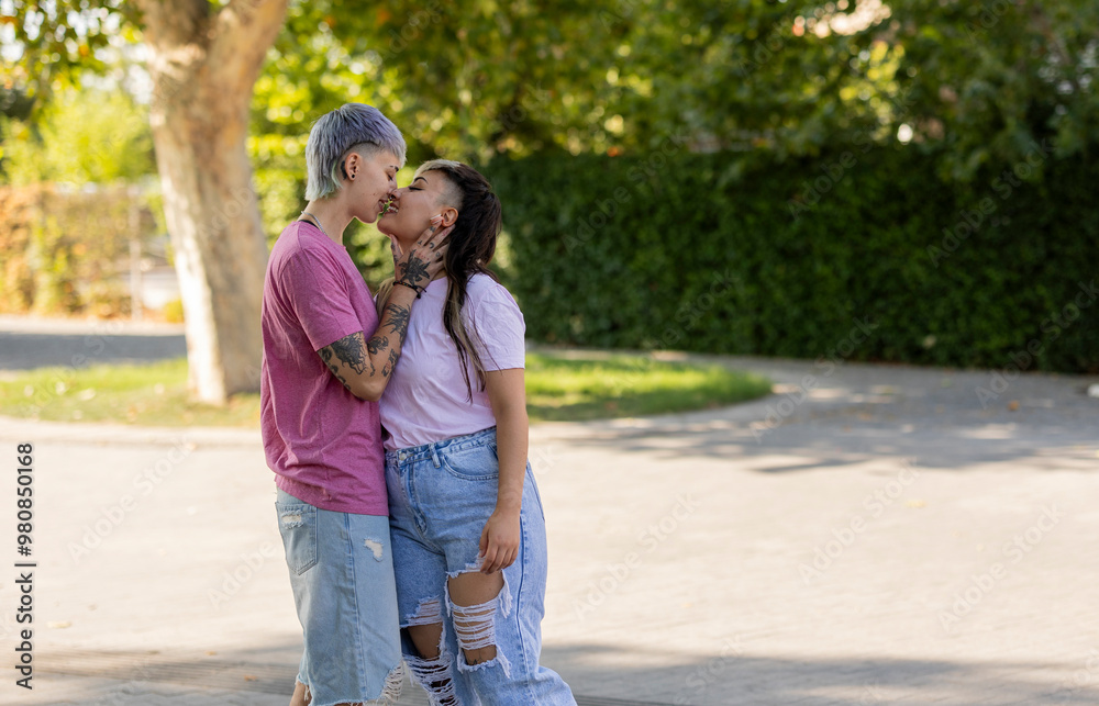 Loving lesbian couple kissing gently in a park Loving lesbian couple kissing gently in a park