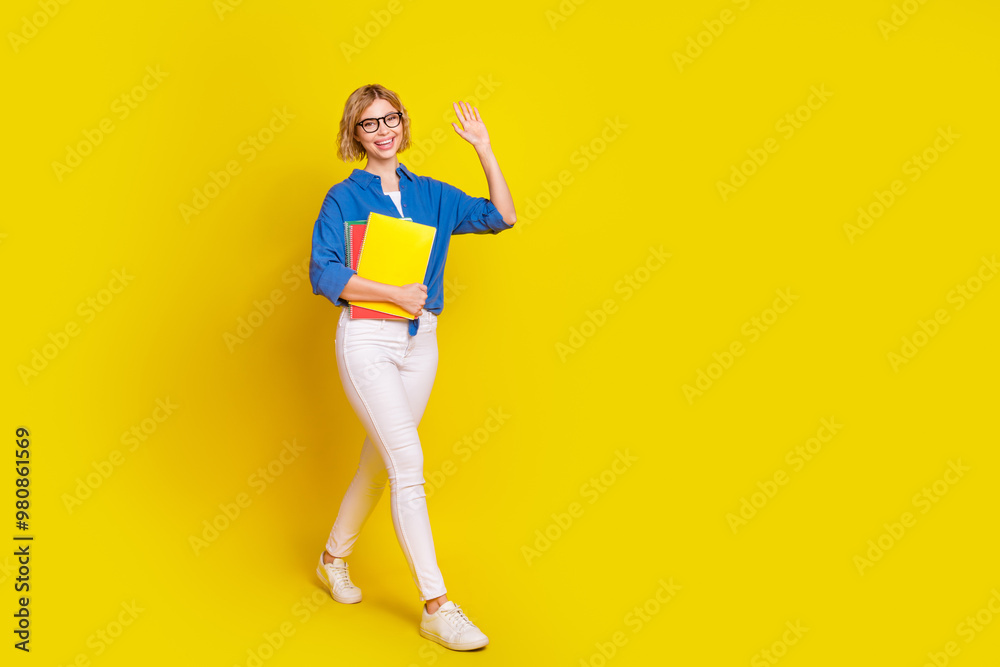 Full size photo of nice young girl book walk empty space wear shirt isolated on yellow color background Full size photo of nice young girl book walk empty space wear shirt isolated on yellow color background