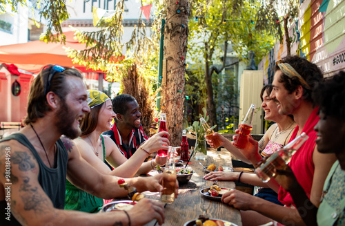 Friends enjoying lunch and toasting drinks at an outdoor hostel