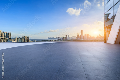 Fototapeta Naklejka Na Ścianę i Meble -  Empty square floor and city skyline with modern buildings scenery at sunrise. car advertising background.