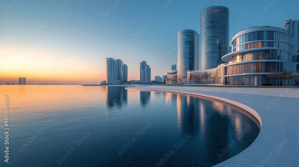 Obraz premium Modern Architecture Reflecting in Calm Water at Sunset