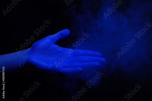 Blue smoke emanates from a glowing hand, ideal for themes involving magic or mystical ideas