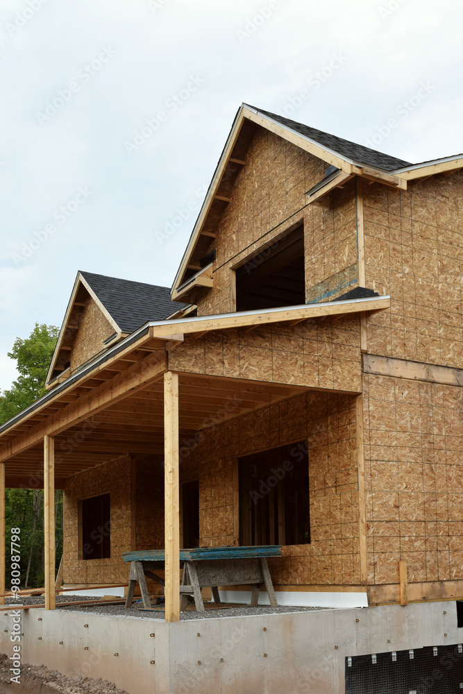 New Home Under Construction with Lumber Framing and Carpentry Builders Craftsman New Home Under Construction with Lumber Framing and Carpentry Builders Craftsman