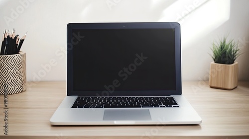 A modern laptop with a closed lid, resting on a minimalist desk