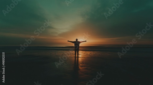 Silhouette of a man in worship on the beach at sunset. photo