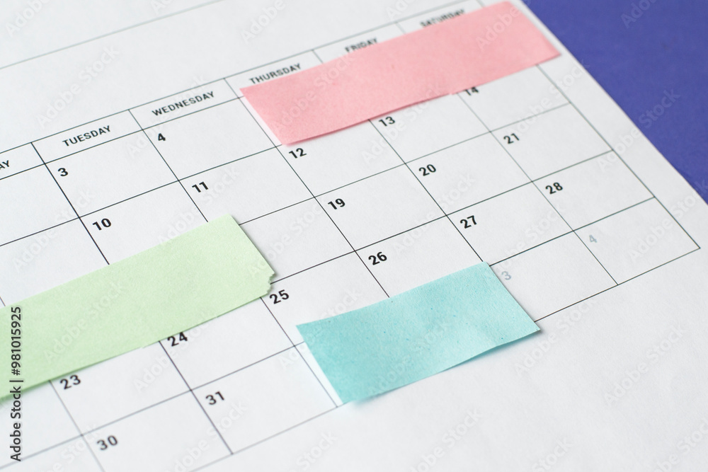 Calendar of the month and several colored adhesive notes to highlight the activities to be done. Copy space. Concept of time organization and achievement of objectives. Calendar of the month and several colored adhesive notes to highlight the activities to be done. Copy space. Concept of time organization and achievement of objectives.