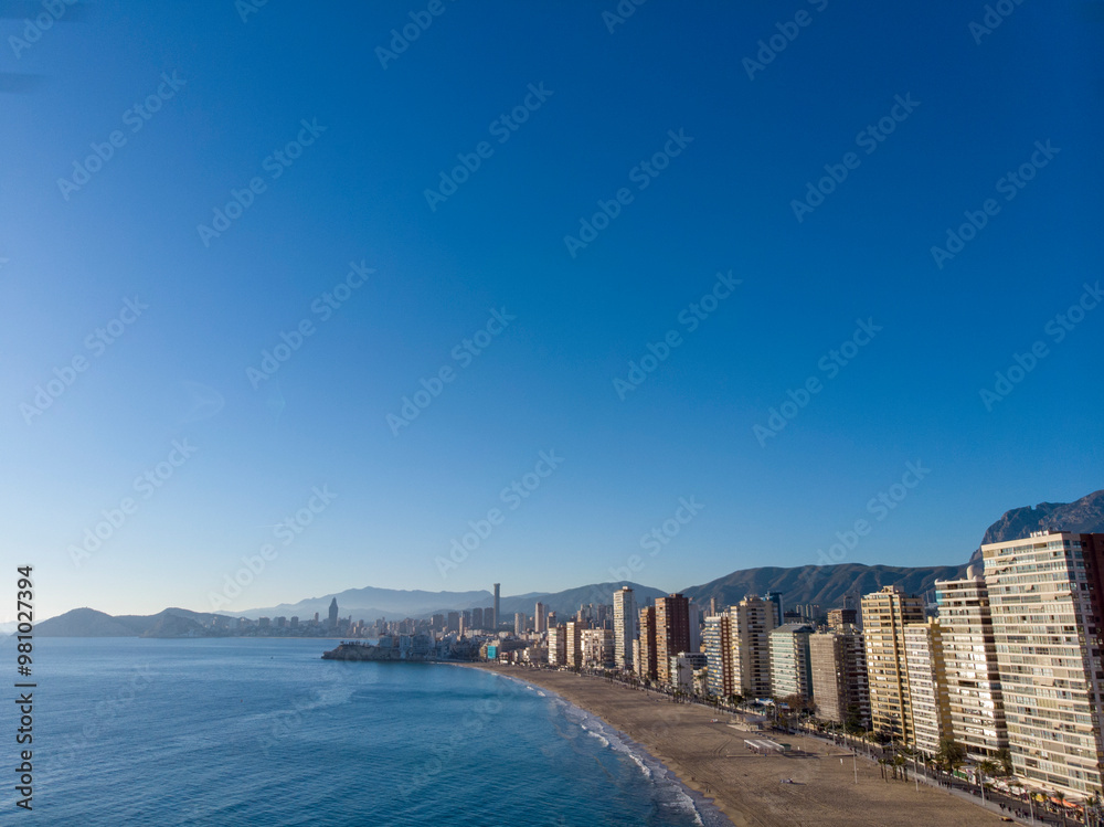 Aerial photo taken in Benidorm in Spain Alicante, showing the beautiful beach of Playa Levante and hotels, buildings, and high rise skyline cityscape. Aerial photo taken in Benidorm in Spain Alicante, showing the beautiful beach of Playa Levante and hotels, buildings, and high rise skyline cityscape.