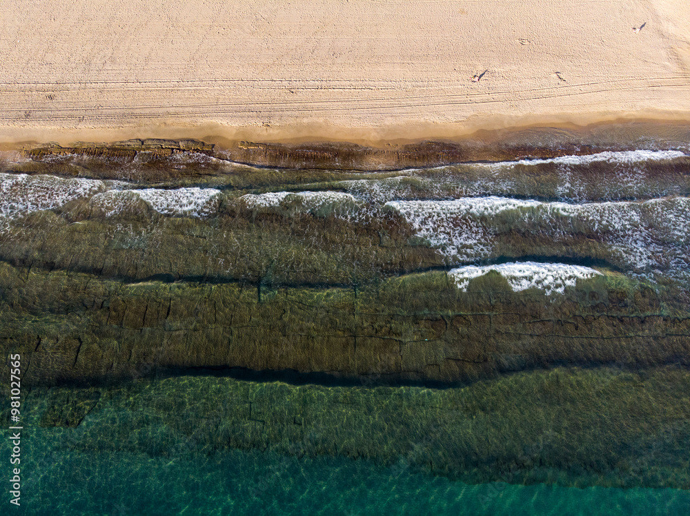 Aerial photo of the beautiful beach taken in the town of Benidorm in Spain, showing a top view of a typical Spanish beach