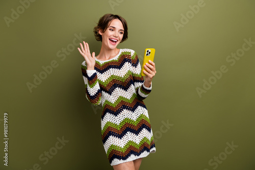 Photo portrait of pretty young girl wave hand videl call gadget dressed stylish print knitted outfit isolated on khaki color background photo