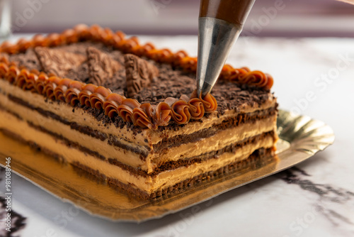 sweet dessert choco cake with chocolate cookies dulce de leche cream cheese on kitchen counter decorated with broken chocolate