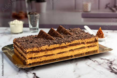 sweet dessert choco cake with chocolate cookies dulce de leche cream cheese on kitchen counter decorated with broken chocolate
