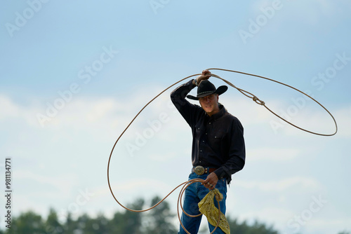 Cowboy performing a lasso trick under a cloudy sky.