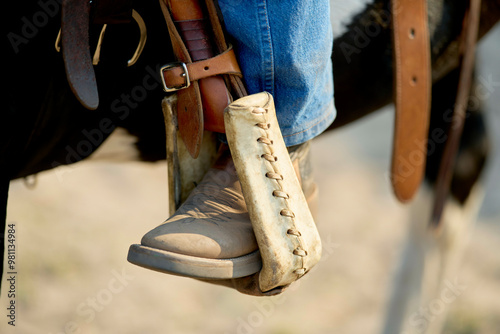 Close-up of a boot in the stirrup of a horse saddle. photo