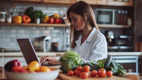 A person uses their laptop in a kitchen setting