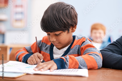 Notebook, writing and boy in classroom for lesson in growth, child development and book for education. Problem solving, learning and students with exam notes, knowledge and study at elementary school