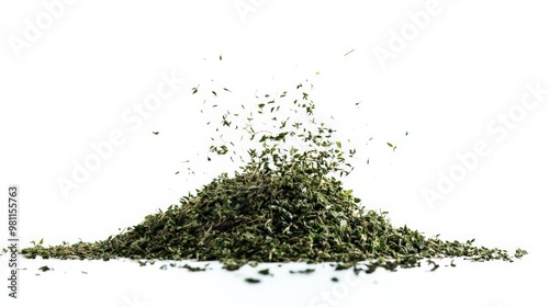 A close-up image of dried green herbs or spices being scattered against a white background. photo