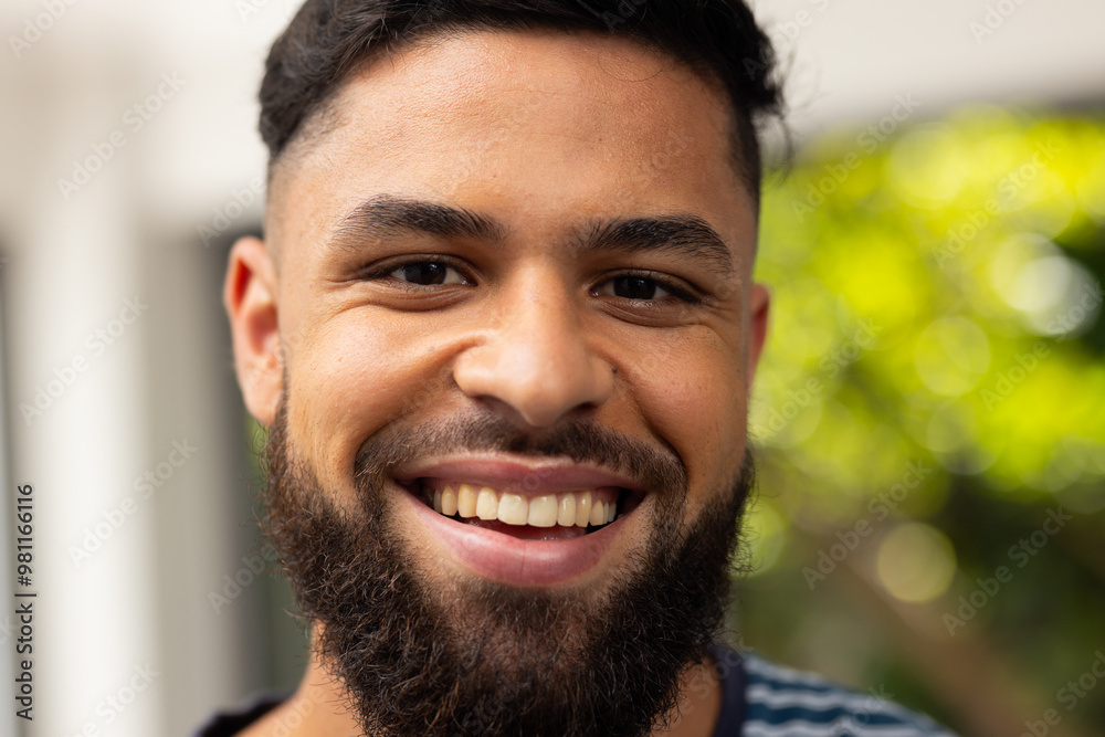 Obraz premium Smiling young man with beard enjoying outdoor time with friends