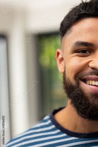 Smiling young man with beard wearing striped shirt, enjoying moment, copy space