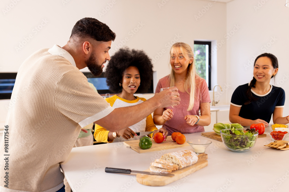 Preparing meal, group of young diverse friends chopping vegetables and laughing together Preparing meal, group of young diverse friends chopping vegetables and laughing together
