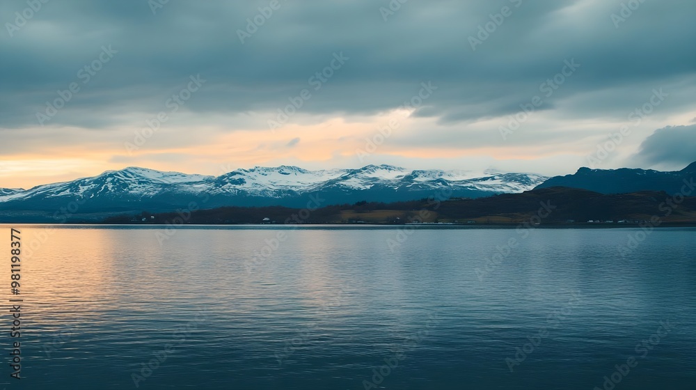 Serene landscape of mountains and water under a cloudy sky at dusk, capturing the beauty of nature's calmness. Serene landscape of mountains and water under a cloudy sky at dusk, capturing the beauty of nature's calmness.