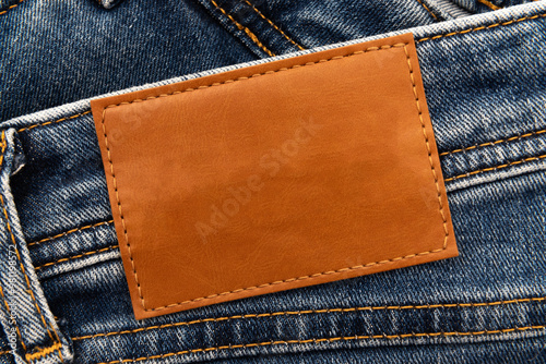 Empty worn leather patch on blue jeans. Empty space for writing. Blank leather jeans label