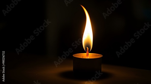 A solitary candle flame glowing softly in a dark environment, creating a serene and tranquil atmosphere.