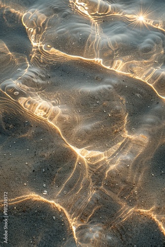 Glistening water ripples on a sandy surface, capturing light and creating mesmerizing reflections and patterns. photo